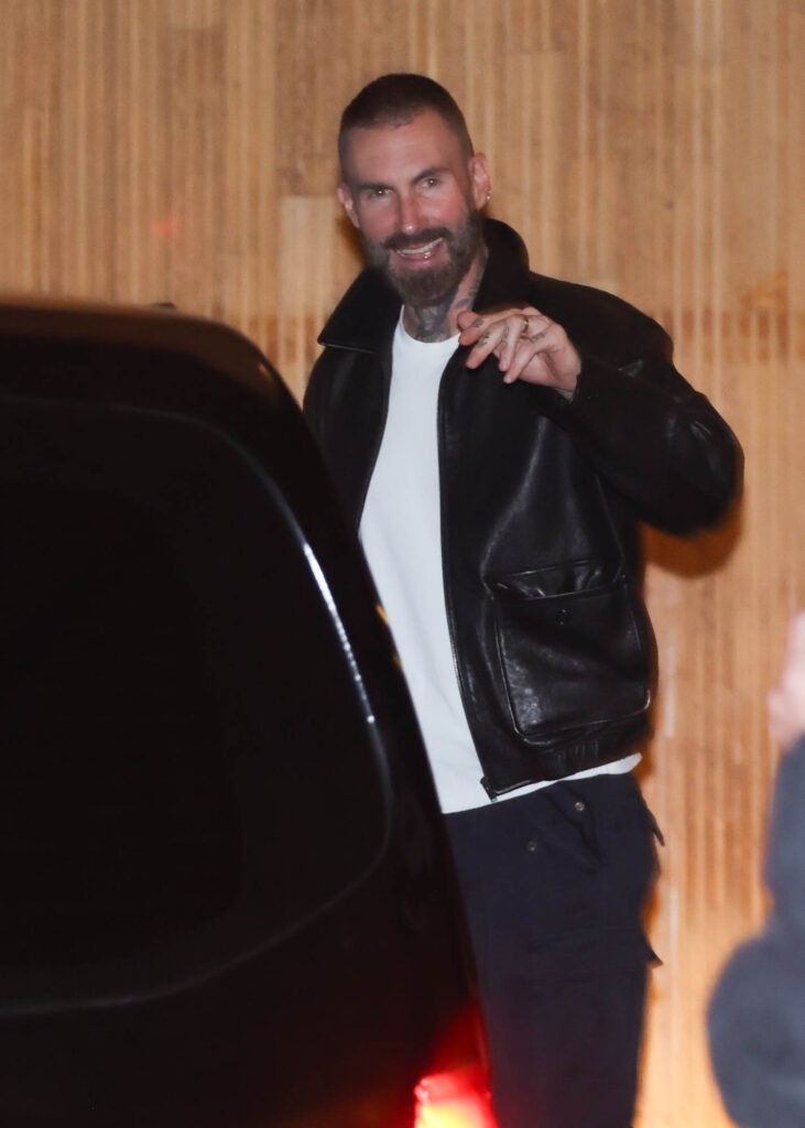 Adam Levine acena ao deixar hotel na capital paulista