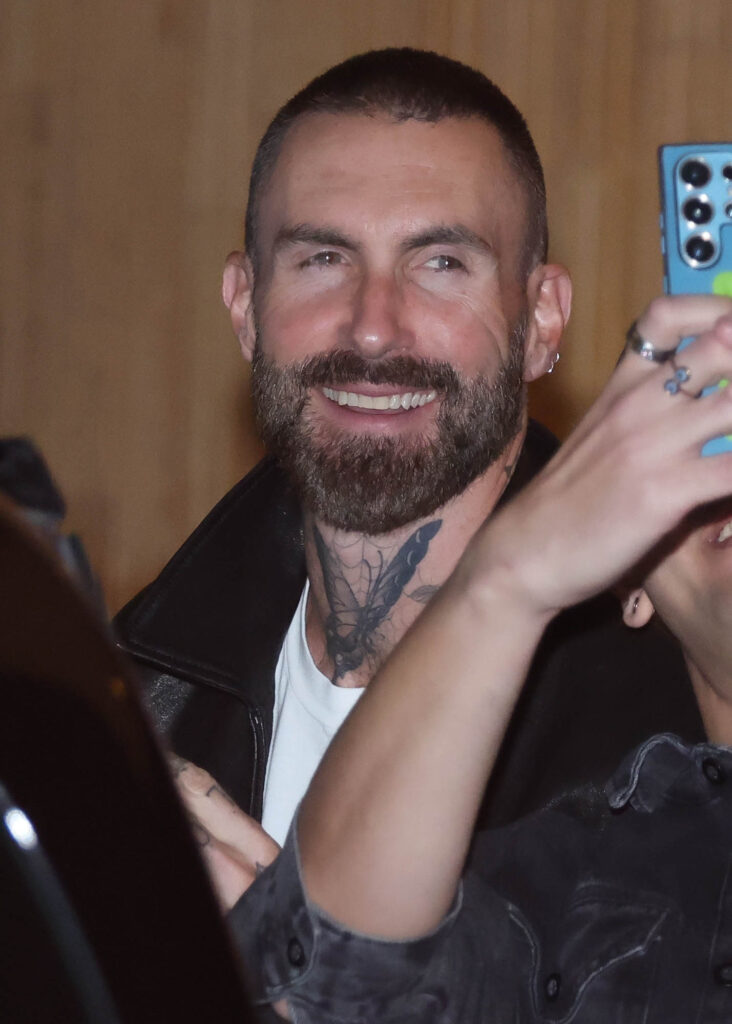 Adam Levine posa para foto com fã na saída de hotel em São Paulo