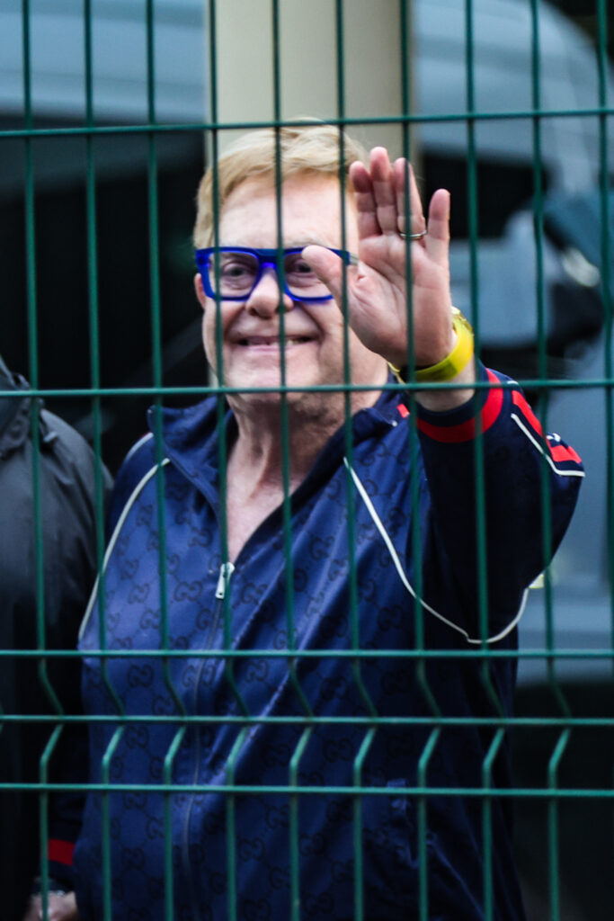 Elton John acena antes do embarque no Aeroporto do Galeão