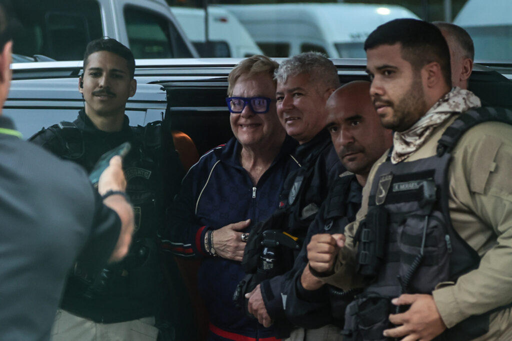 Elton John posa com integrantes de sua equipe antes do embarque
