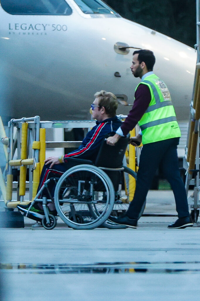 Elton John é conduzido até aeronave antes de embarque no Rio de Janeiro