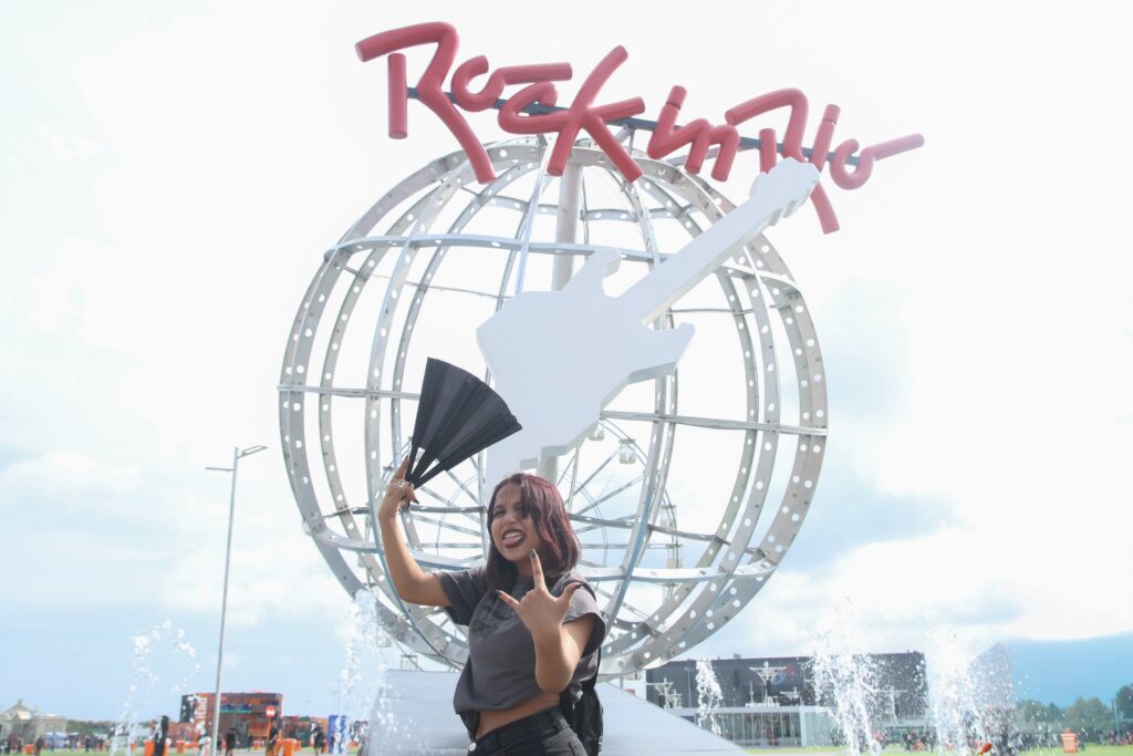 Fã posa diante do globo do Rock in Rio