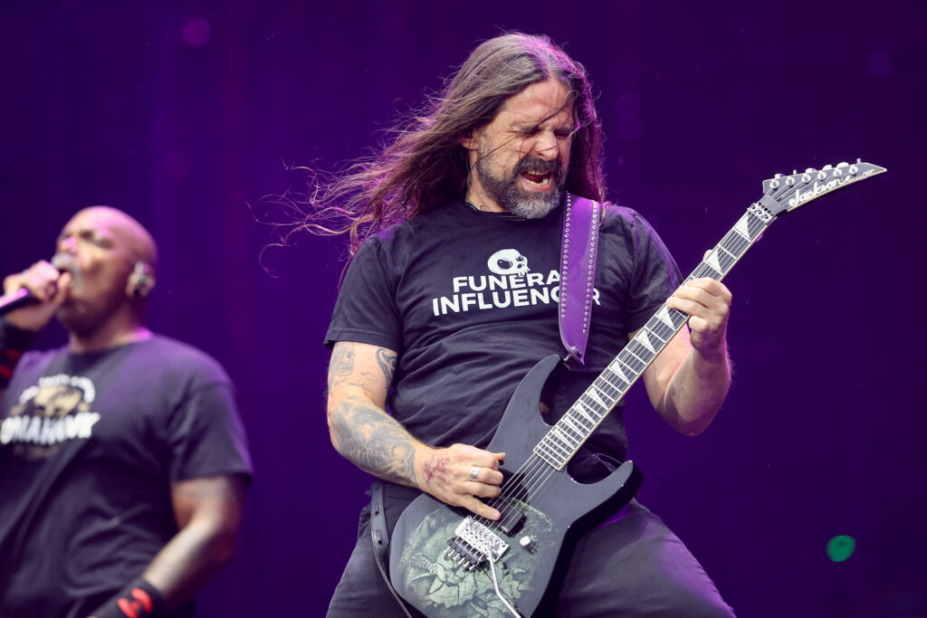 Andreas Kisser toca guitarra com Derrick Green ao fundo no Rock in Rio 2026