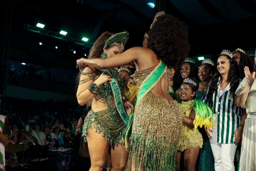 Paolla Oliveira abraça IZA durante a passagem da faixa de rainha de bateria